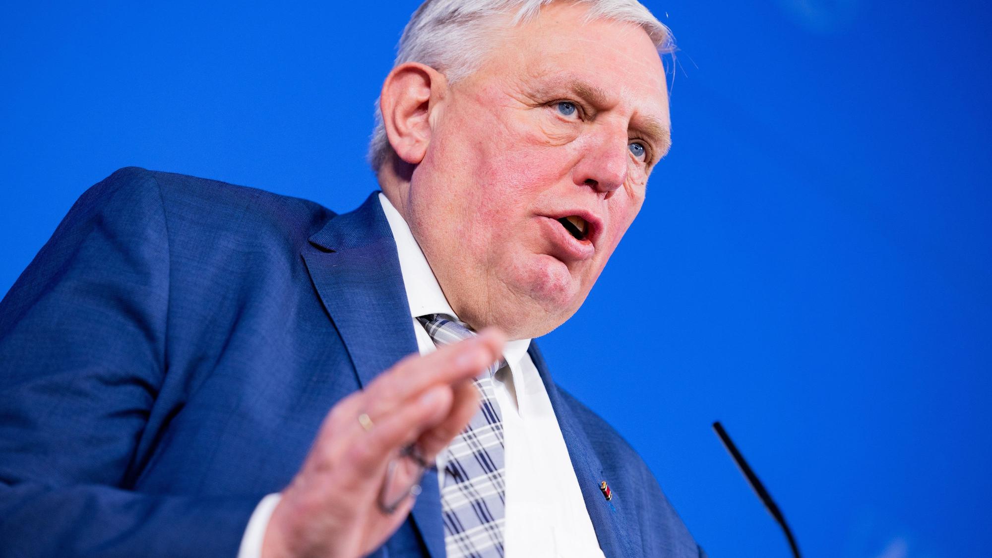 NRW-Gesundheitsminister Karl-Josef Laumann (CDU) spricht im blauen Anzug auf einem Podium.