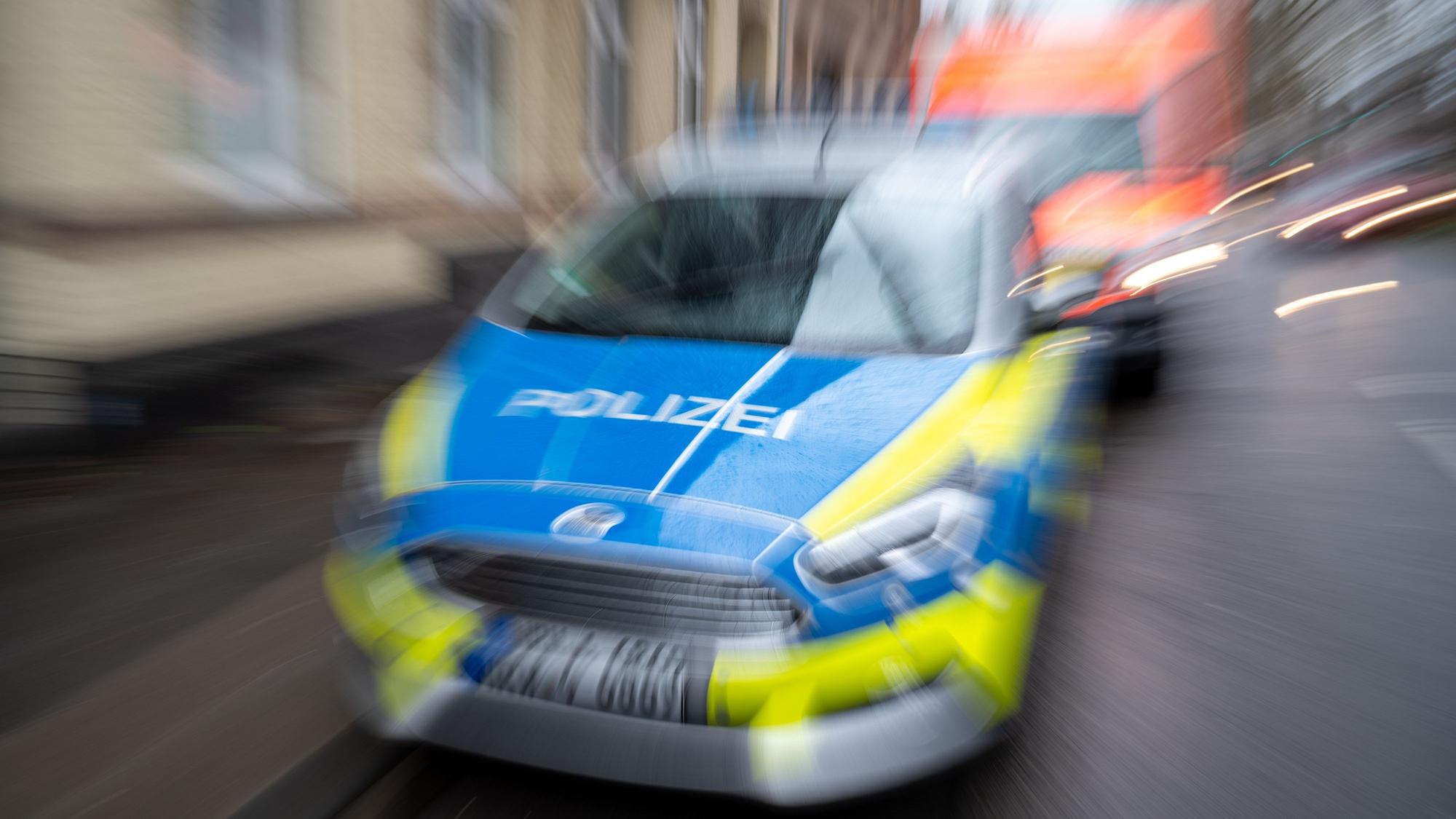 Ein Polizeiauto fährt in einer verwackelten Aufnahme. (Symbolbild)