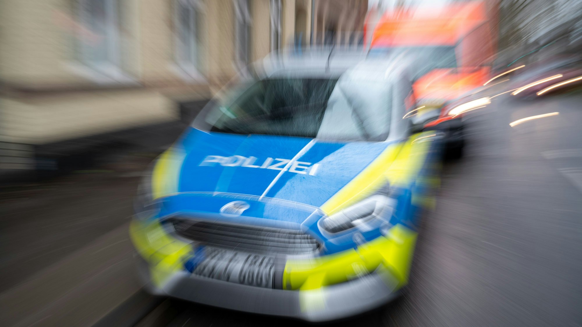 Ein Polizeiauto fährt in einer verwackelten Aufnahme. (Symbolbild)