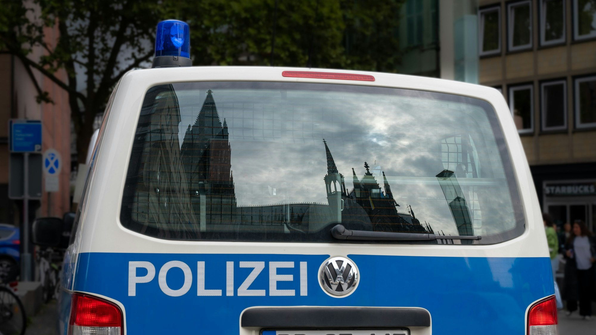 Der Dom spiegelt sich in einem Fenster eines Polizeifahrzeuges.