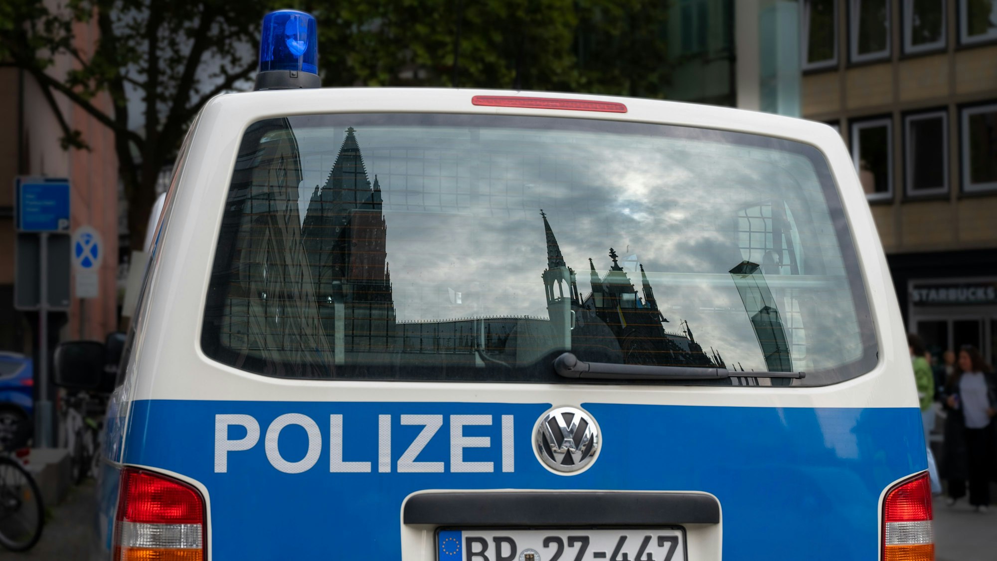 Auto der Polizei, in der Rückscheibe spiegelt sich der Dom