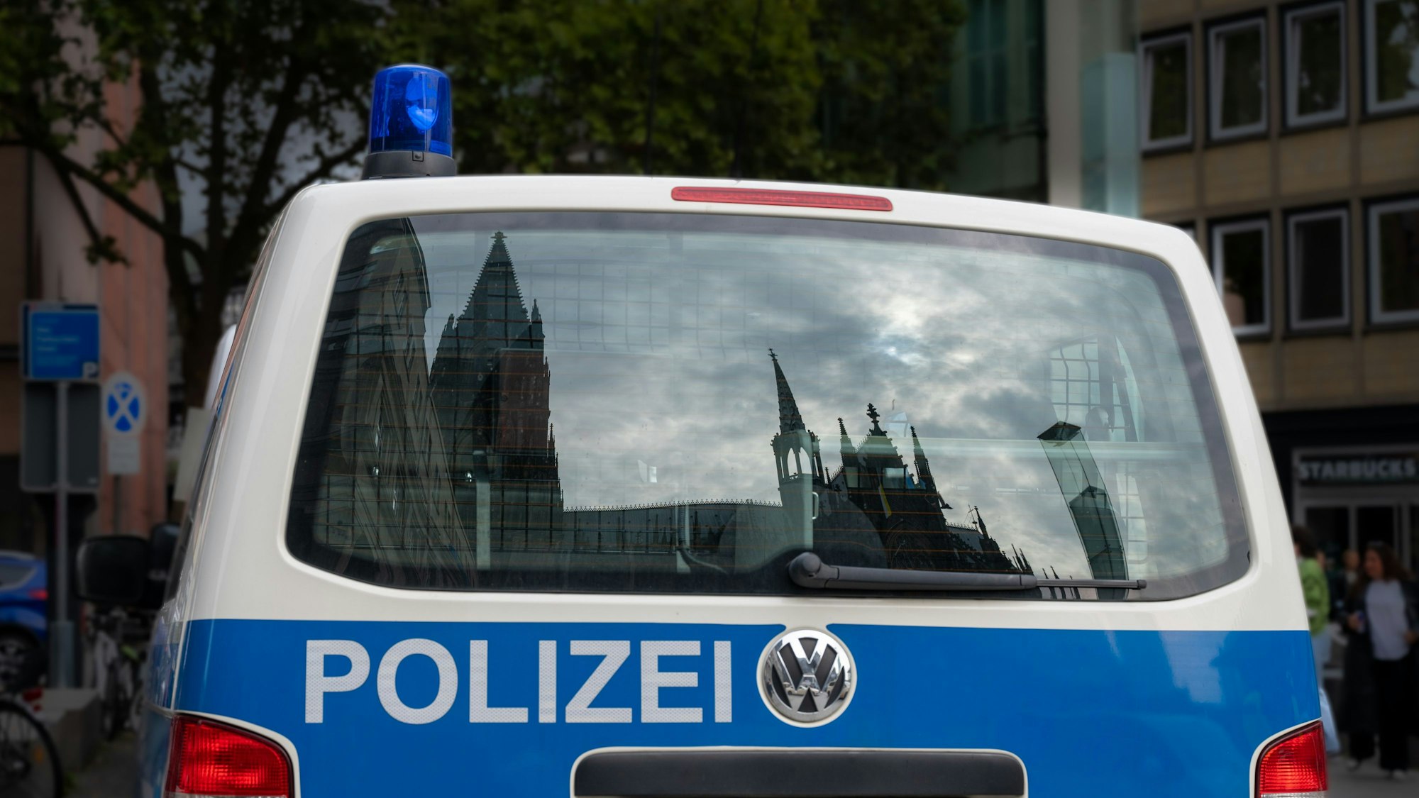 Der Dom spiegelt sich in einem Fenster eines Polizeifahrzeuges.