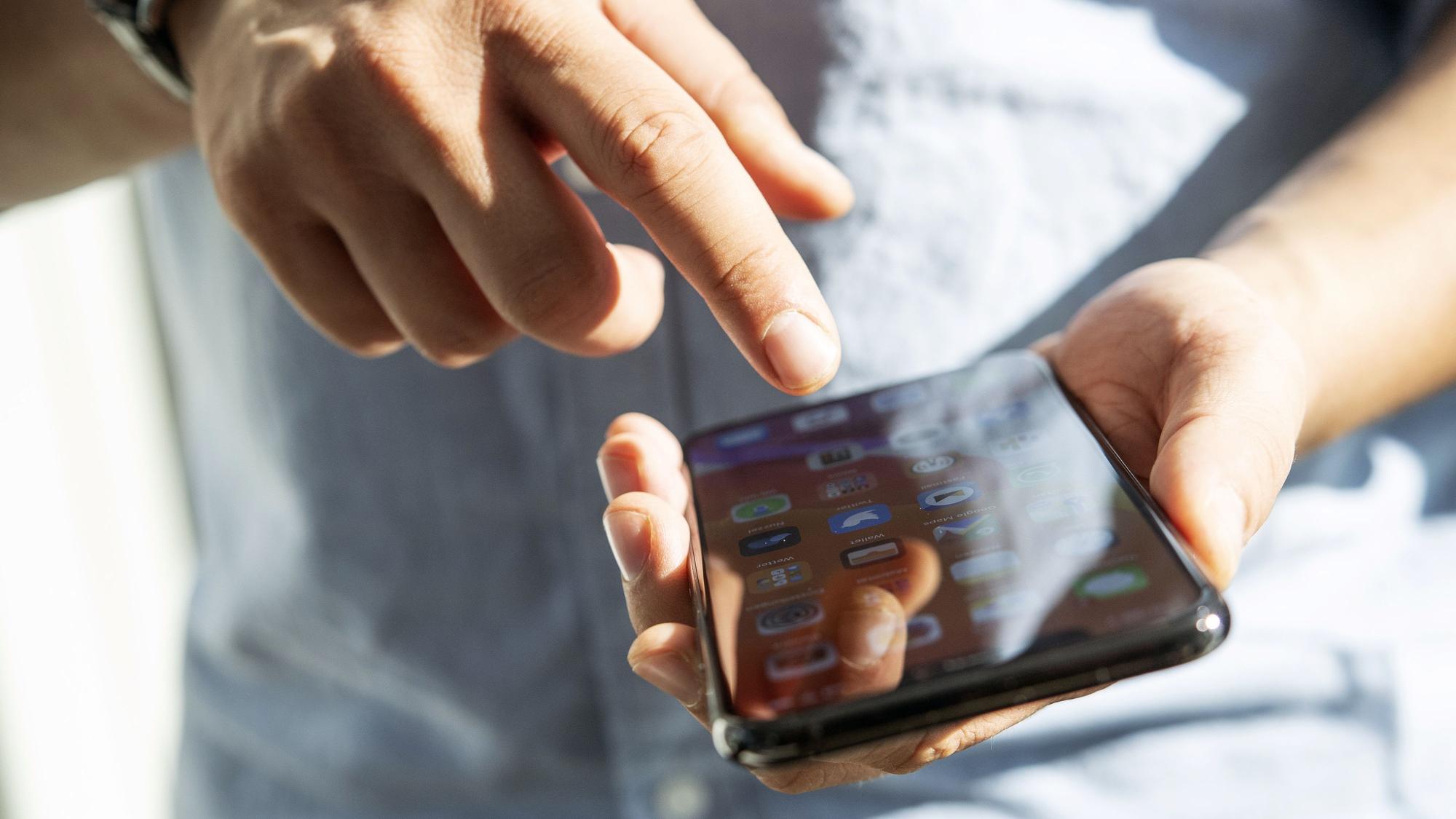 Ein Mann tippt auf seinem Smartphone.
