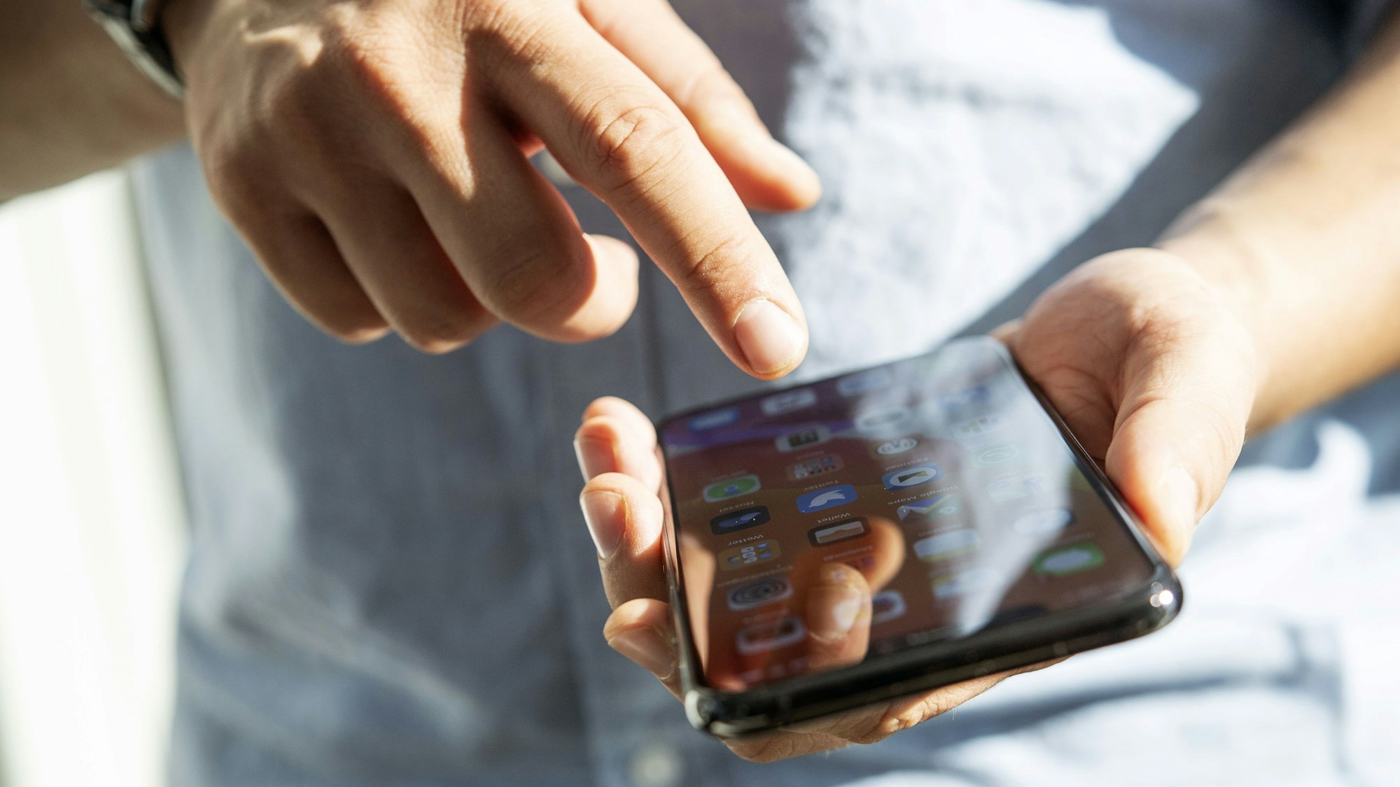 Ein Mann tippt auf seinem Smartphone.