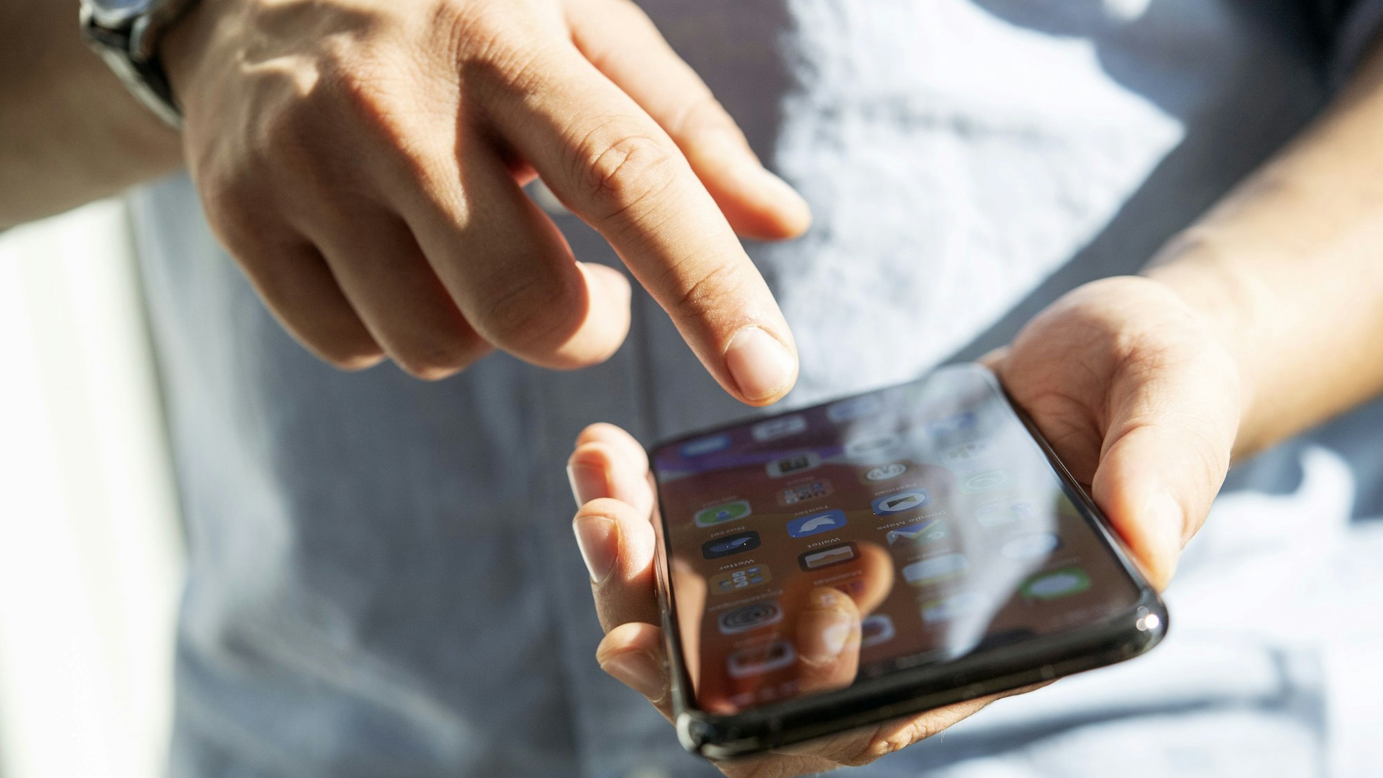 Ein Mann tippt auf seinem Handy.