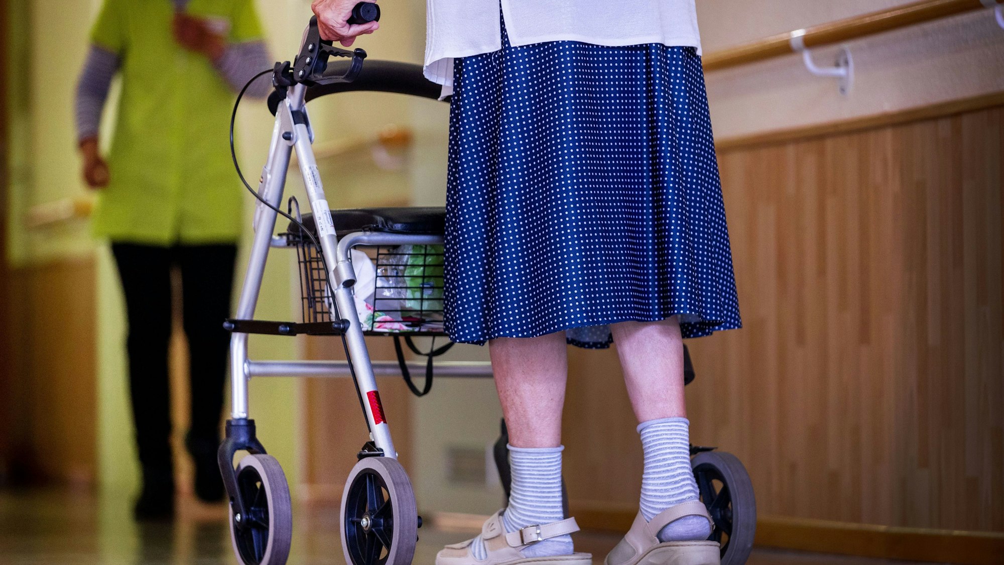 Frau mit Rollator begegnet einer Altenpflegerin