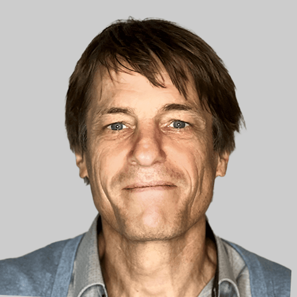 Ein junger Mann steht in einem Garten.