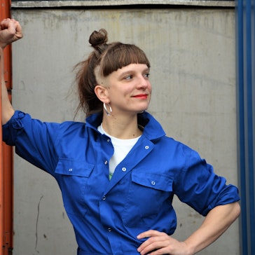 Musikerin Jenny Thiele steht vor einer Wand