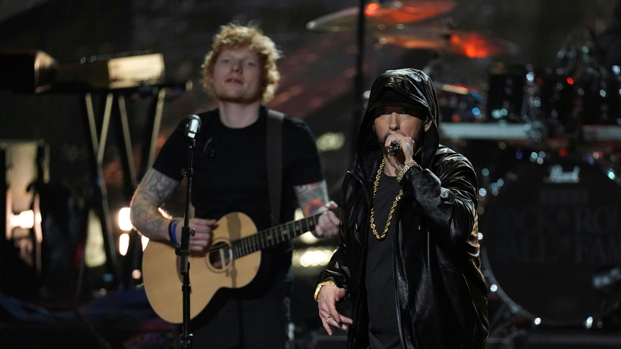 Ed Sheeran mit Gitarre steht links neben Rapper Eminem während der Einführungszeremonie der Rock & Roll Hall of Fame 2022 im Microsoft Theater in Los Angeles.