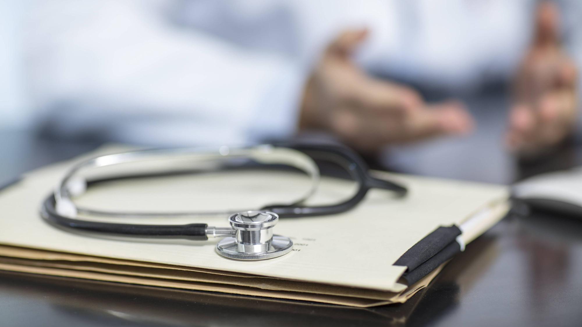Files and stethoscope on desk in medical practice with doctor in background model released Symbolfoto property released PUBLICATIONxINxGERxSUIxAUTxHUNxONLY ZEF15505