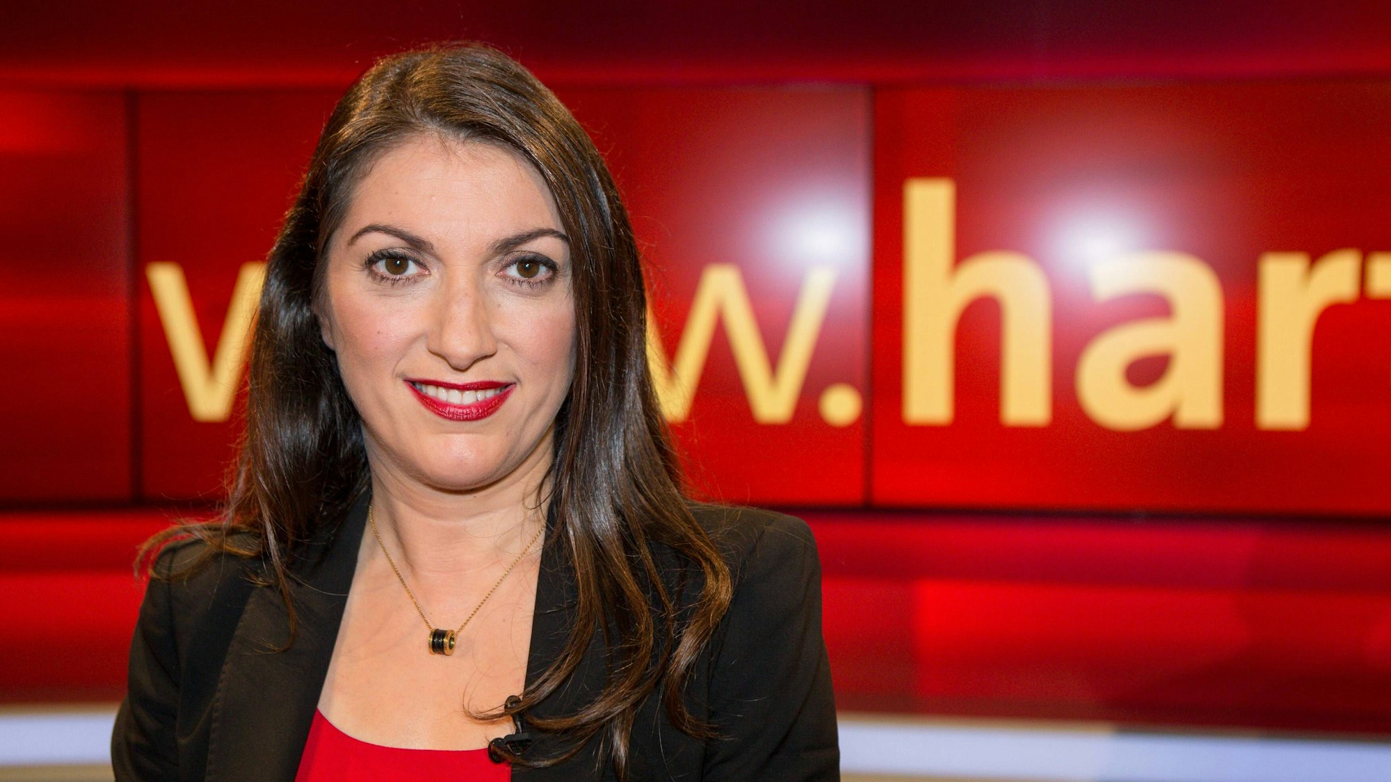 Emitis Pohl steht im „hart aber fair“ Studio. Sie lächelt in die Kamera.