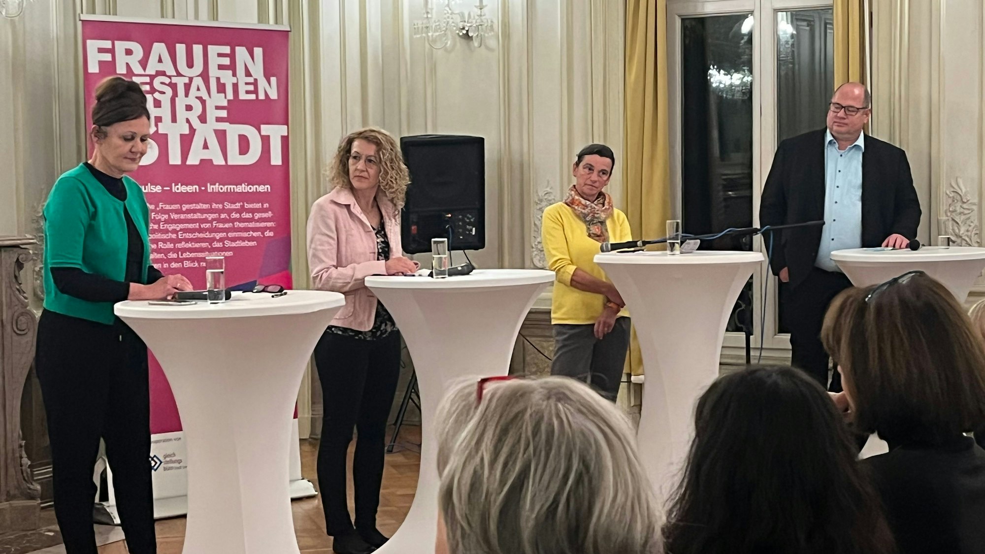 Claudia Wiese, Melanie Went, Monika Ballin-Meyer-Ahrens und Stefan Hebbel stehen an Stehtischen im Spiegelsaal von Schloss Morsbroich.