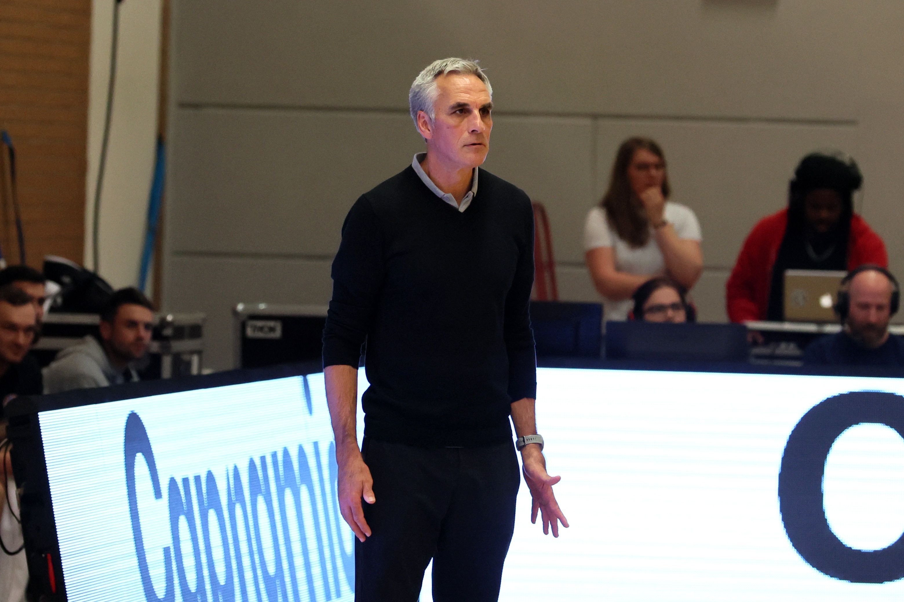 Ein Basketball-Trainer steht am Spielfeldrand uns beobachtet sein Team.