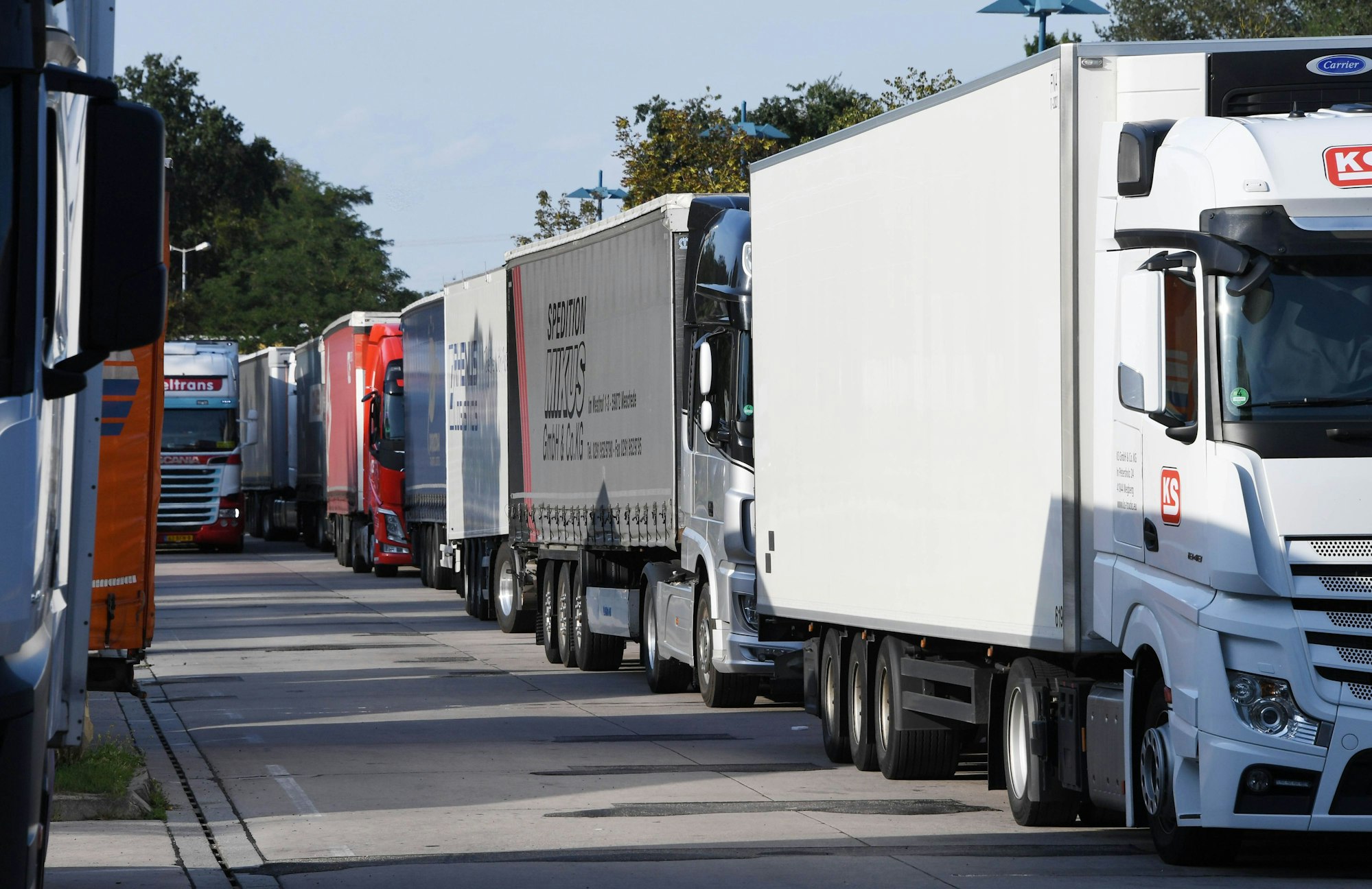 Auf einem Rastplatz stehen geparkte Lkw dicht aneinander.