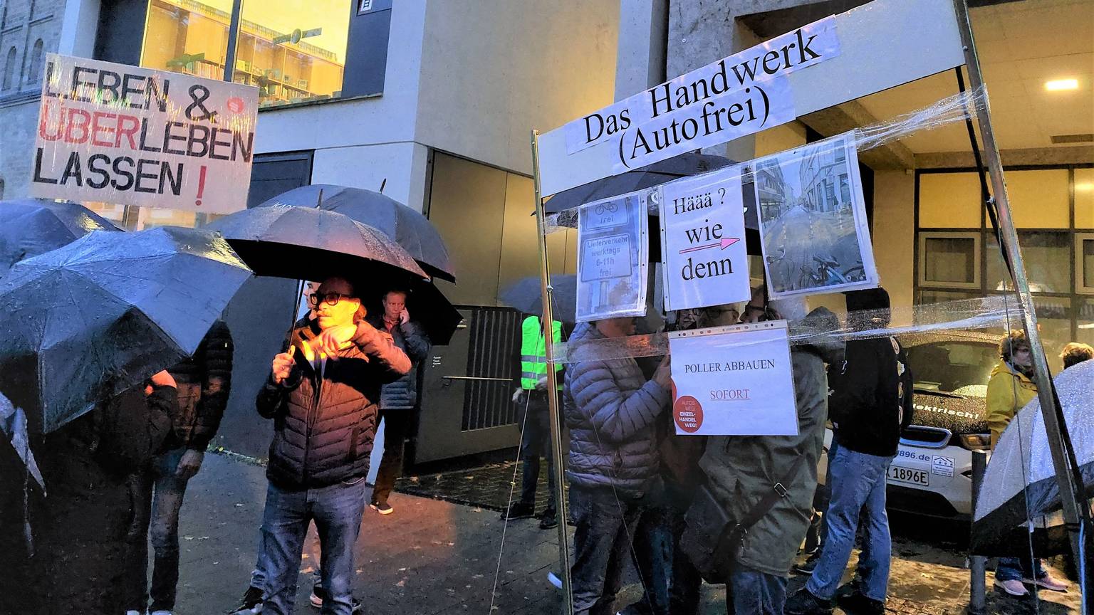 300 Anwohner und Händler zeigen Schilder, auf denen sie die Verkehrsregelung auf der Deutzer Freiheit kritisieren.