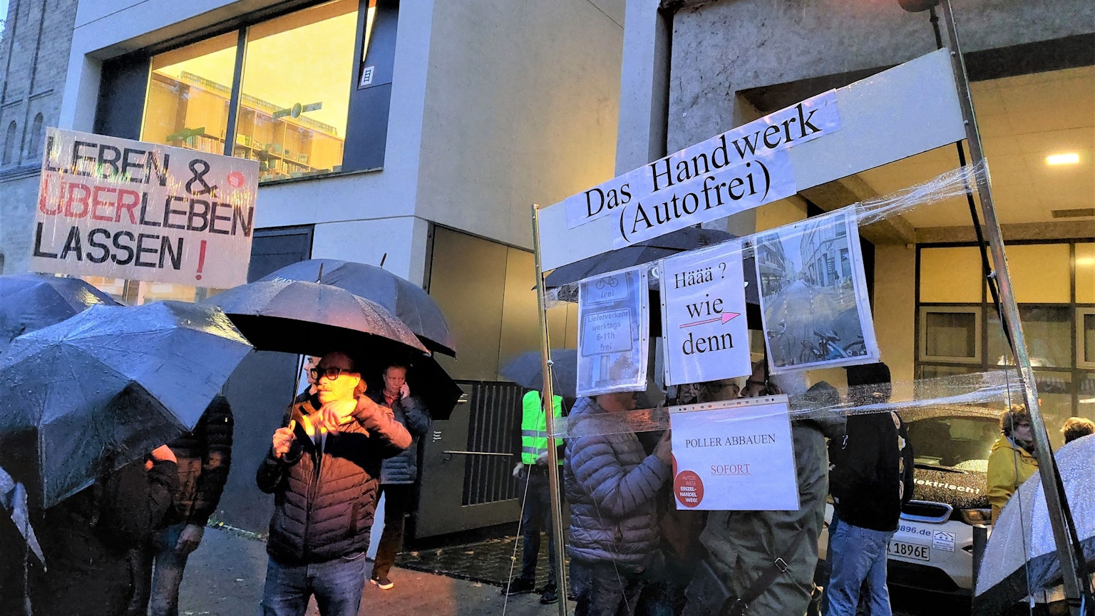 300 Anwohner und Händler zeigen Schilder, auf denen sie die Verkehrsregelung auf der Deutzer Freiheit kritisieren.