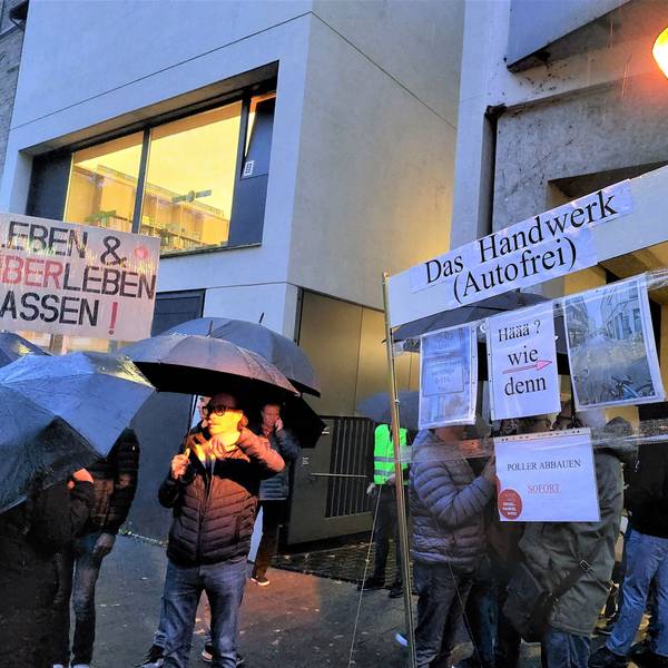 300 Anwohner und Händler zeigen Schilder, auf denen sie die Verkehrsregelung auf der Deutzer Freiheit kritisieren.
