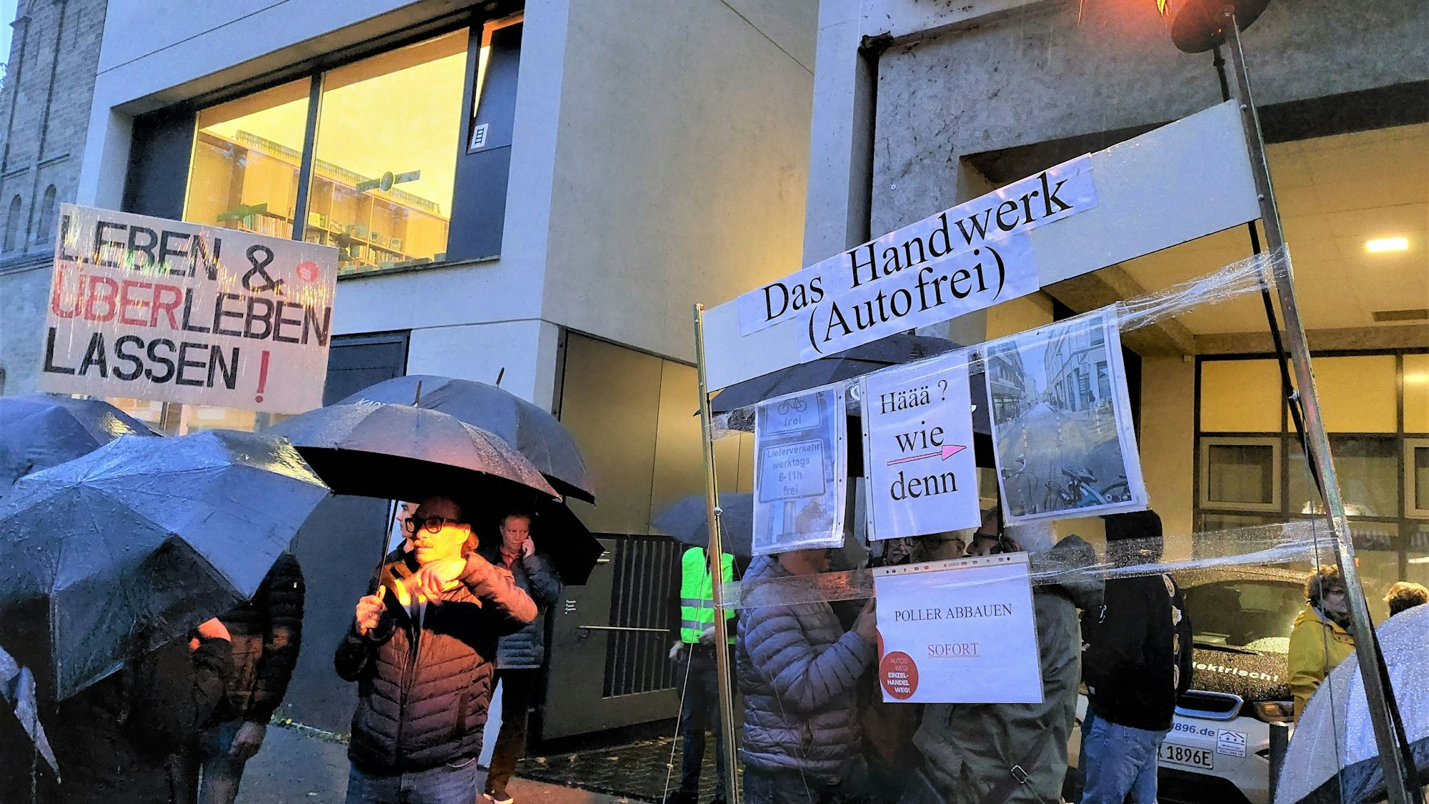 300 Anwohner und Händler zeigen Schilder, auf denen sie die Verkehrsregelung auf der Deutzer Freiheit kritisieren.