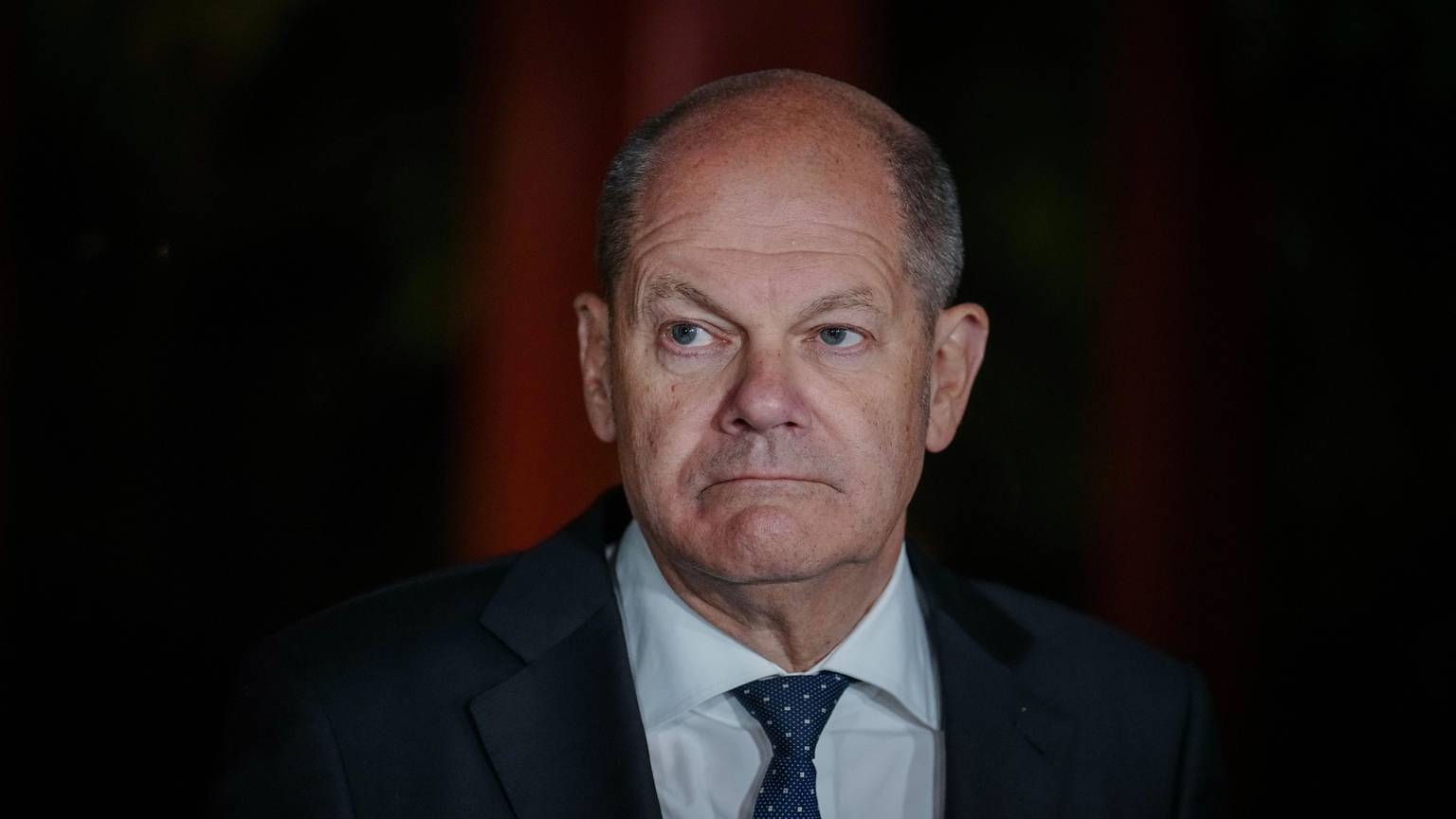 Bundeskanzler Olaf Scholz schaut auf einem Pressetermin ernst in die Kamera.