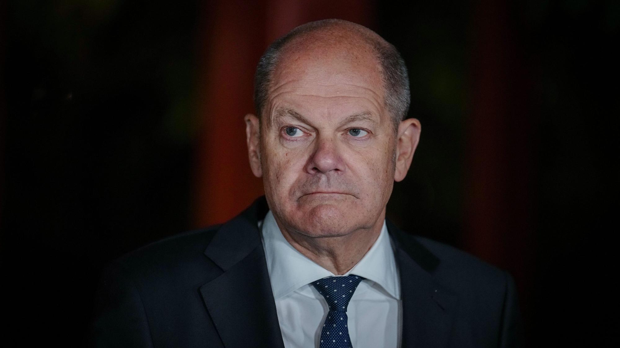 Bundeskanzler Olaf Scholz schaut auf einem Pressetermin ernst in die Kamera.