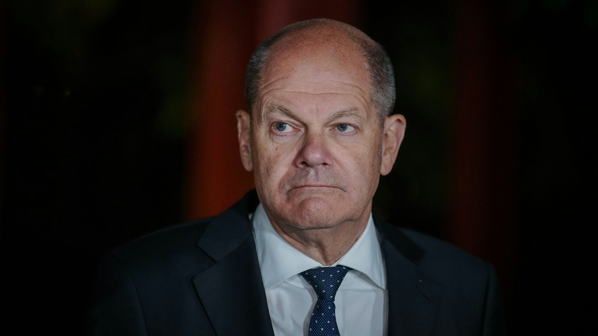 Bundeskanzler Olaf Scholz schaut auf einem Pressetermin ernst in die Kamera.