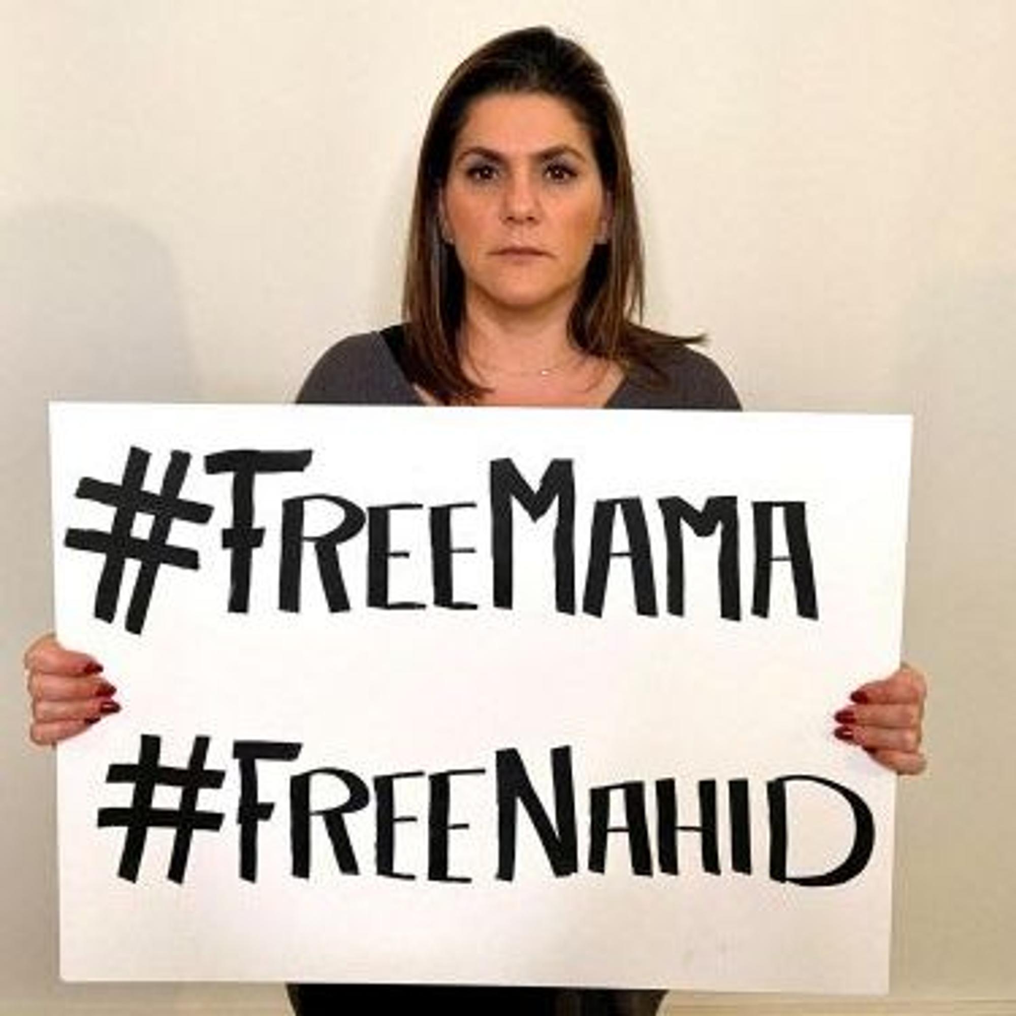 Mariam Claren hält ein Schild mit der Aufschrift „#FreeMama, #FreeNahid“ in die Kamera