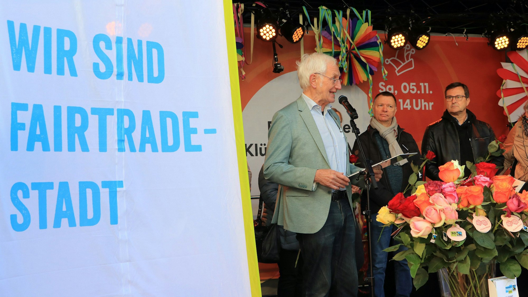 Menschen stehen neben einem Schild Wir sind Fairtrade-Stadt.