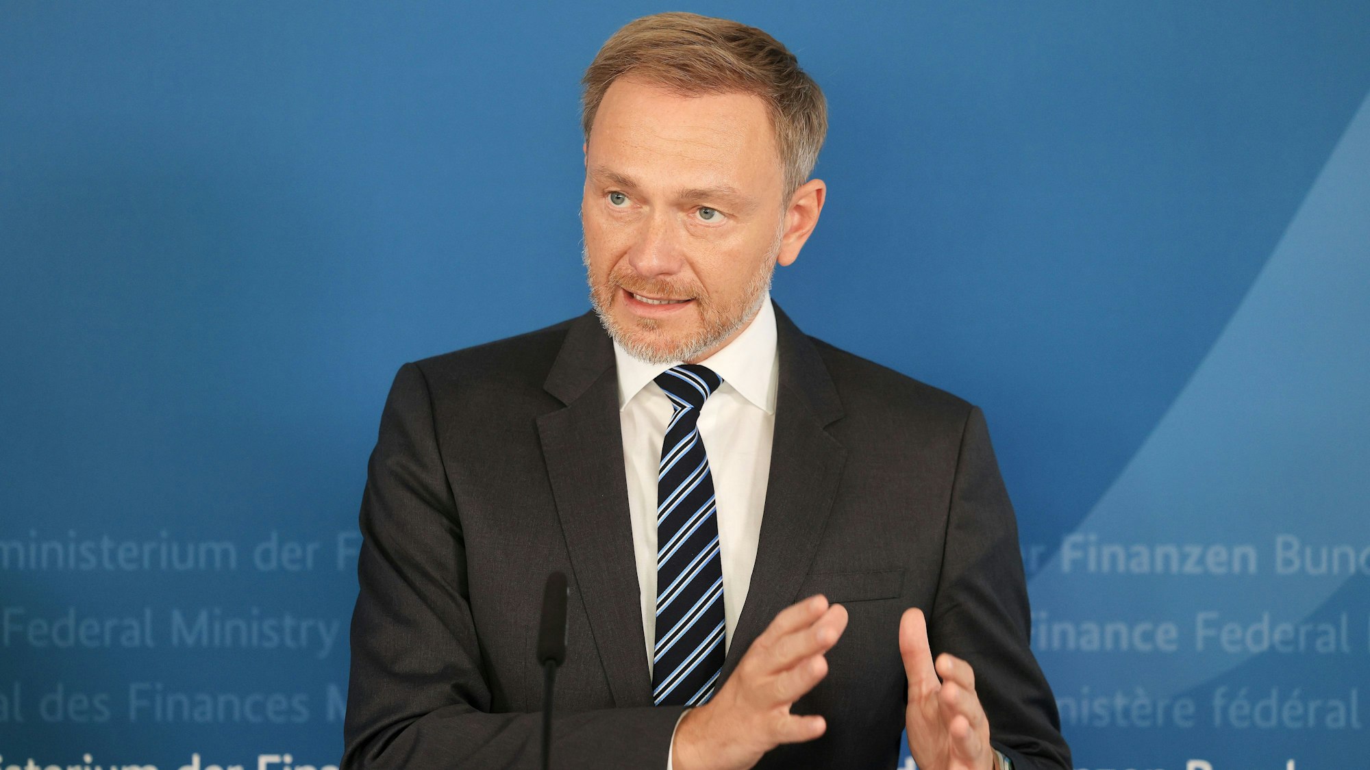 Christian Lindner steht am Podium und redet. Er sieht ernst aus und gestikuliert mit den Händen.