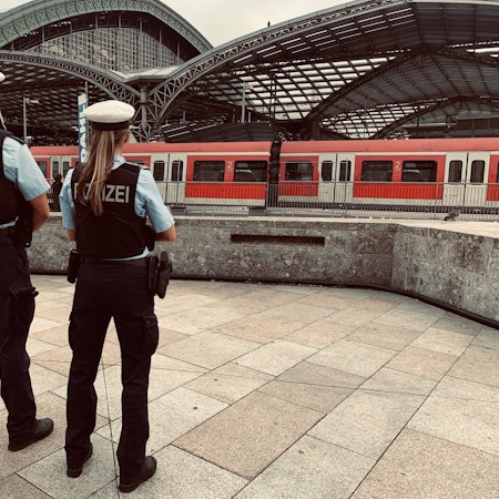 Zwei Bundespolizisten stehen vor dem Kölner Hauptbahnhof.