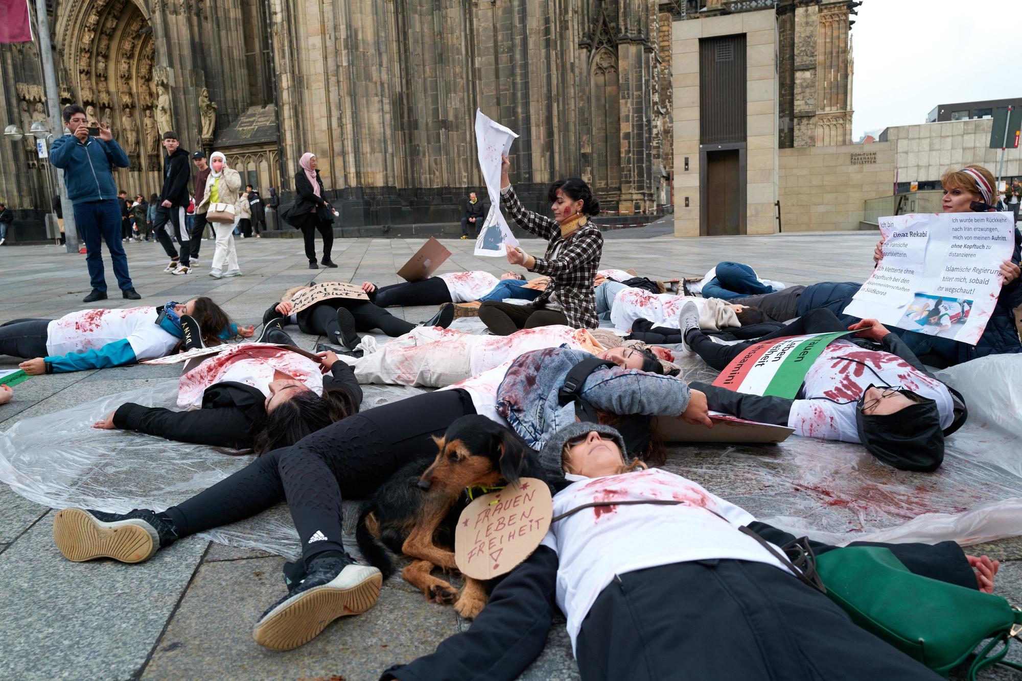 Rund 20 Personen (überwiegend Frauen) legen sich auf die Domplatte und beschmieren ihre weißen T-Shit mit Kunstblut. Damit wollen Sie auf die aktuellen Zustände im Iran aufmerksam machen.