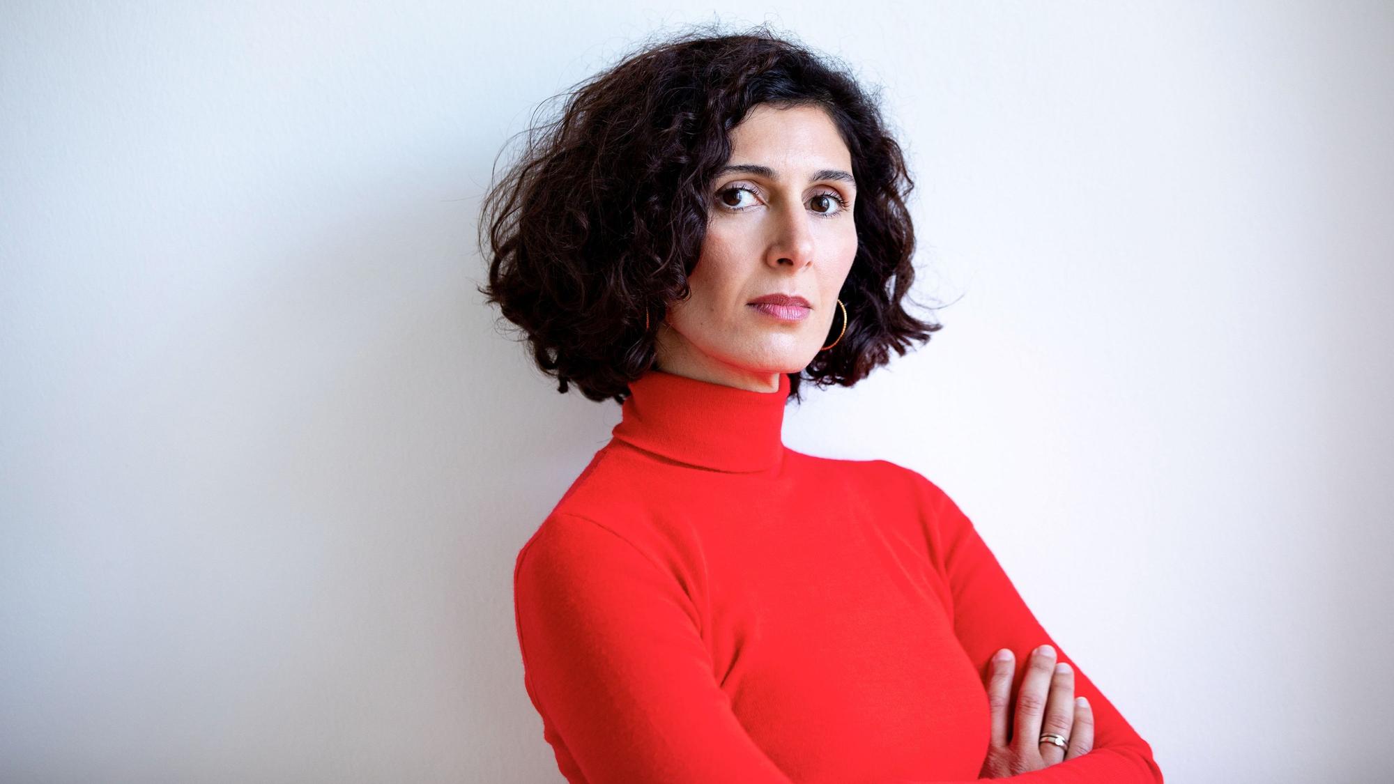 Nava Ebrahimi hat die Arme verschränkt und guckt in die Kamera.