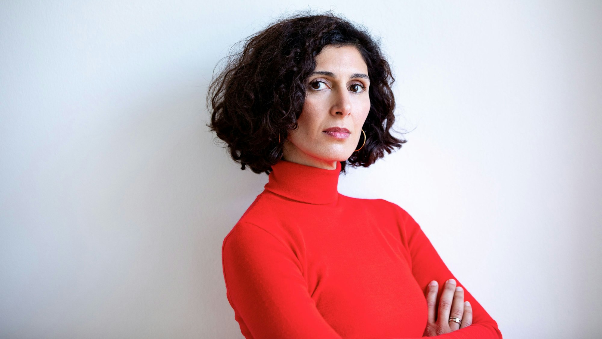 Nava Ebrahimi hat die Arme verschränkt und guckt in die Kamera.