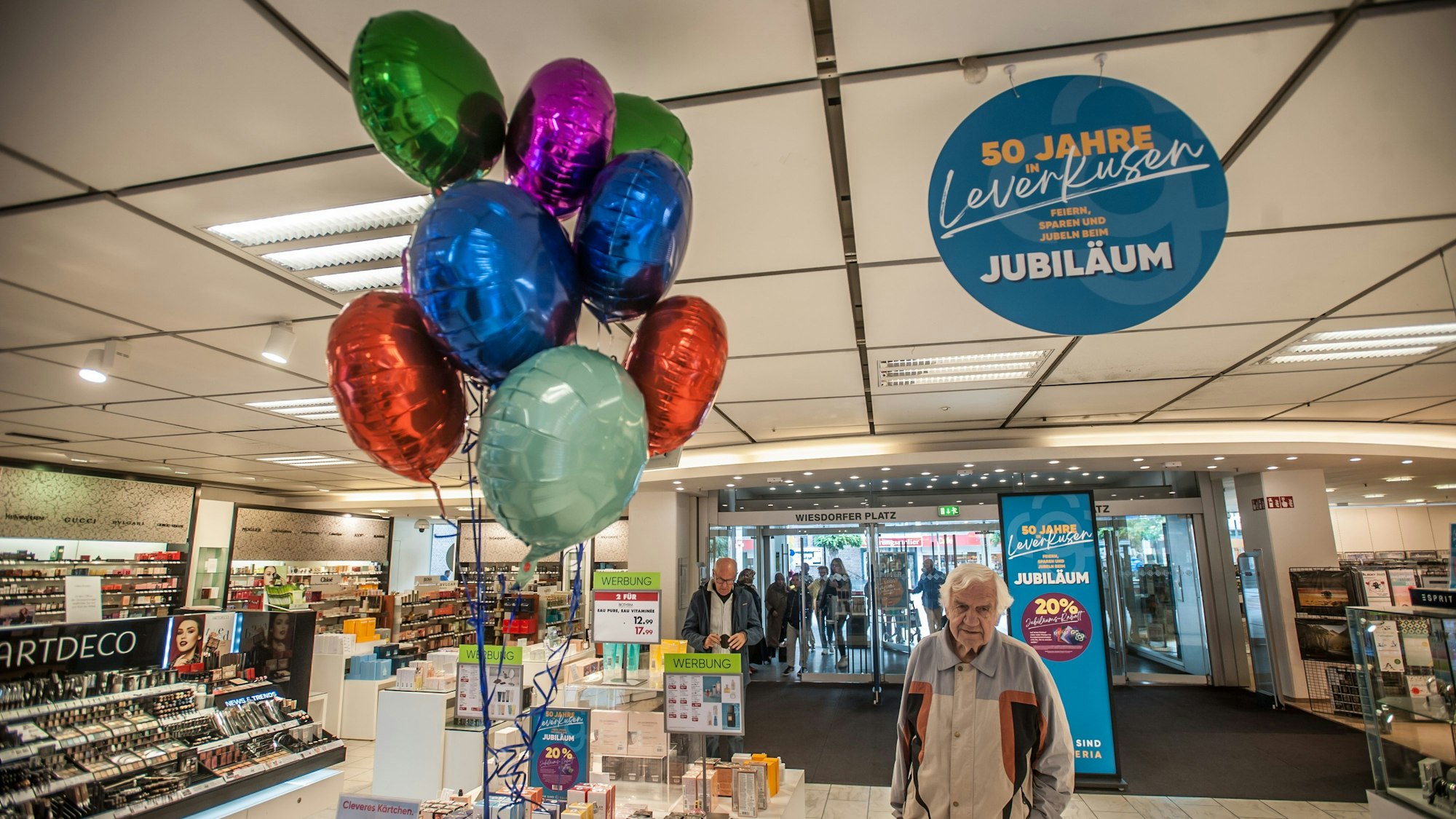 Eingangsbereich der Leverkusener Filiale von Galeria Karstadt Kaufhof beim 50. Jubiläum, das Ende September gefeiert wurde. Ein Kunde steht neben Luftballons.