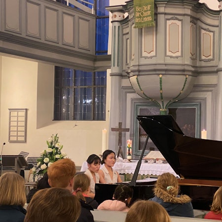 Die Pianistinnen Kanon Yokoyama und Kotone Yokoyama sitzen vor Publikum am Klavier in der evangelischen Kirche in Leichlingen-Witzhelden.
