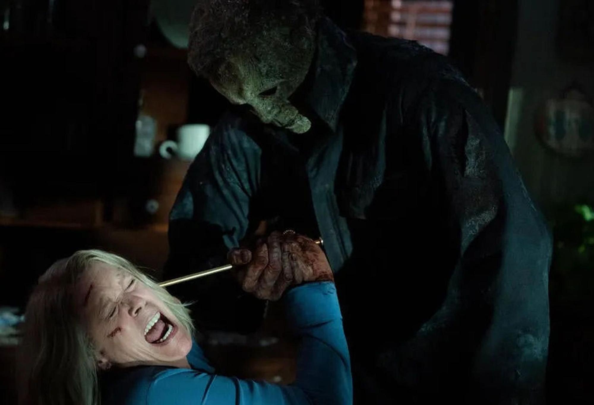 Michael Myers in dunkler Jacke geht mit einem spitzen Gegenstand auf Laurie alias Jamie Lee Curtis los. Sie schreit und wehrt sich.