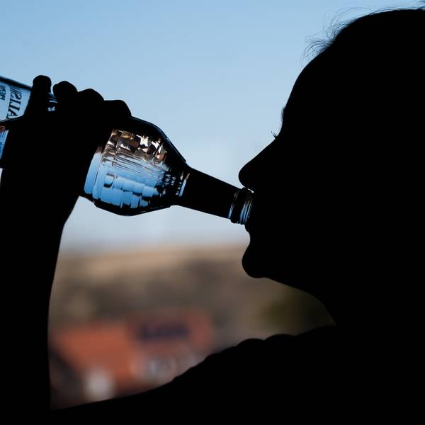 Ein Mädchen trinkt an einer Flasche Wodka.