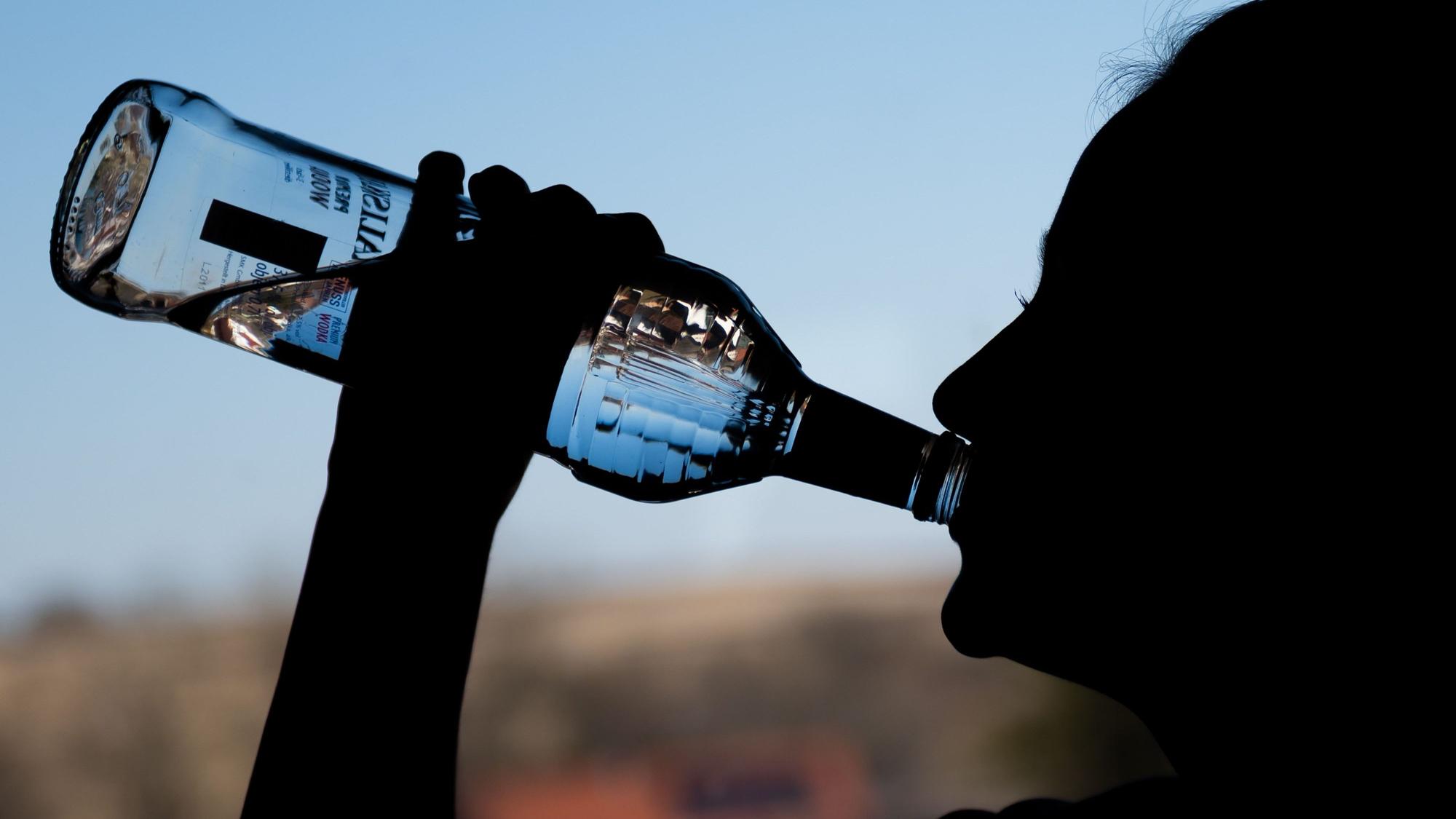 Ein Mädchen trinkt in ihrem Zimmer eine Flasche Wodka. (Symbolbild)