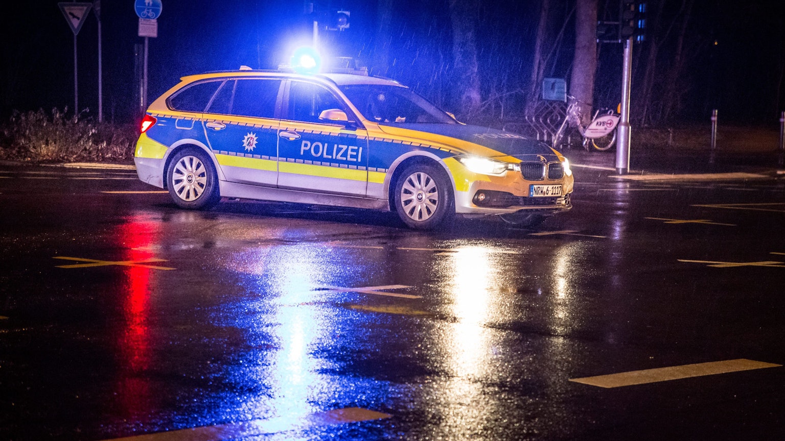 Ein Polizeiauto bei Nacht mit Blaulicht.