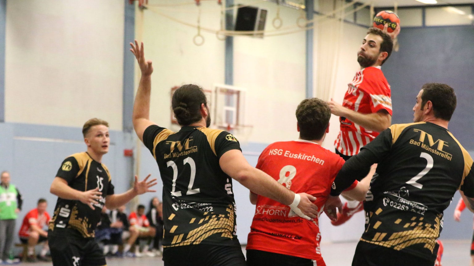 Ein Handballer wirft umringt von Gegenspielern seinen Ball.