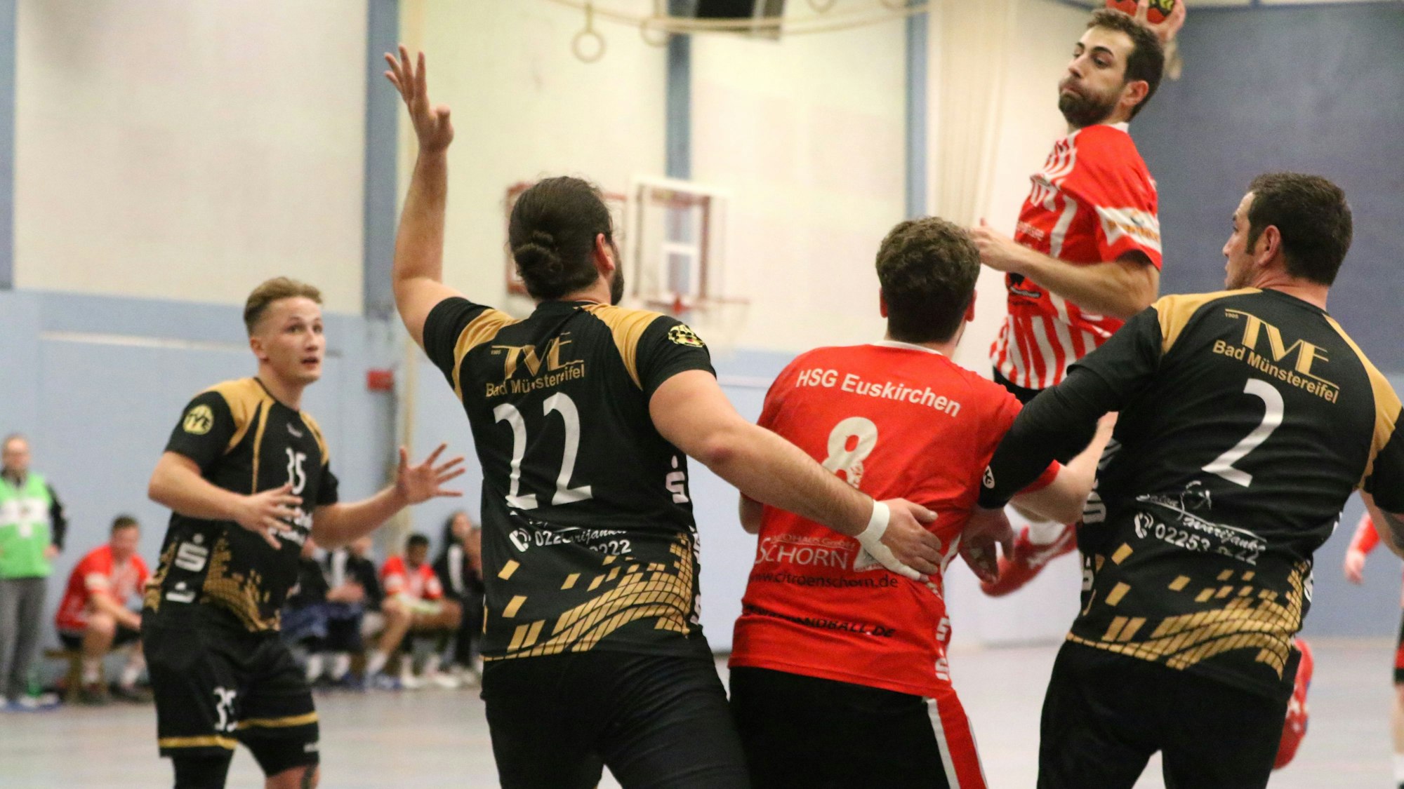 Ein Handballer wirft umringt von Gegenspielern seinen Ball.