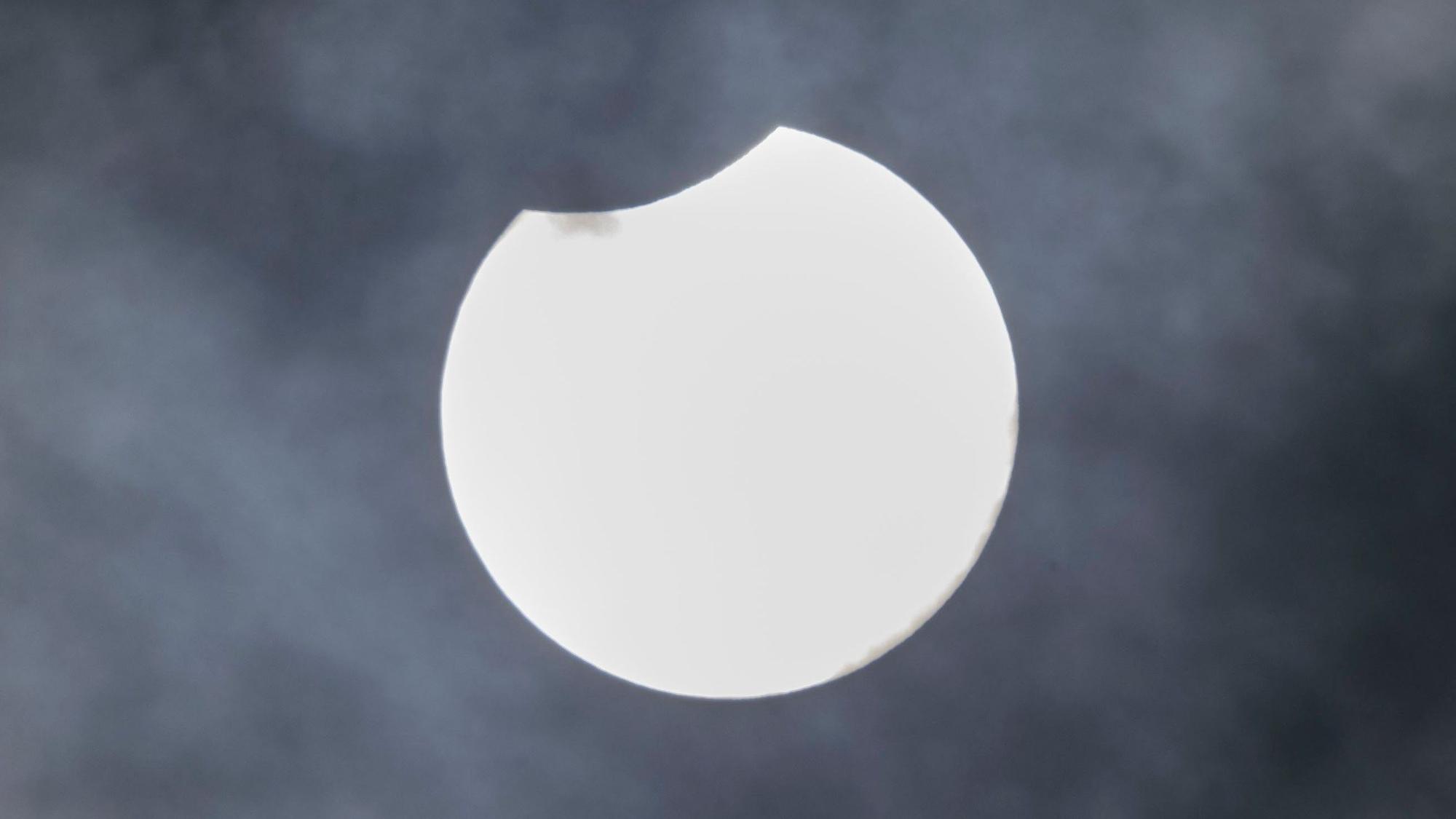 Der Mond verdeckt einen kleinen Teil der Sonne über Köln.