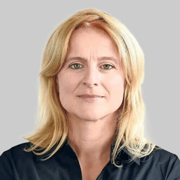 EIne Frau, umringt von Blumensträußen, trauert um David Carroll, der von der Hamas im Kibbuz Beeri umgebracht wurde.