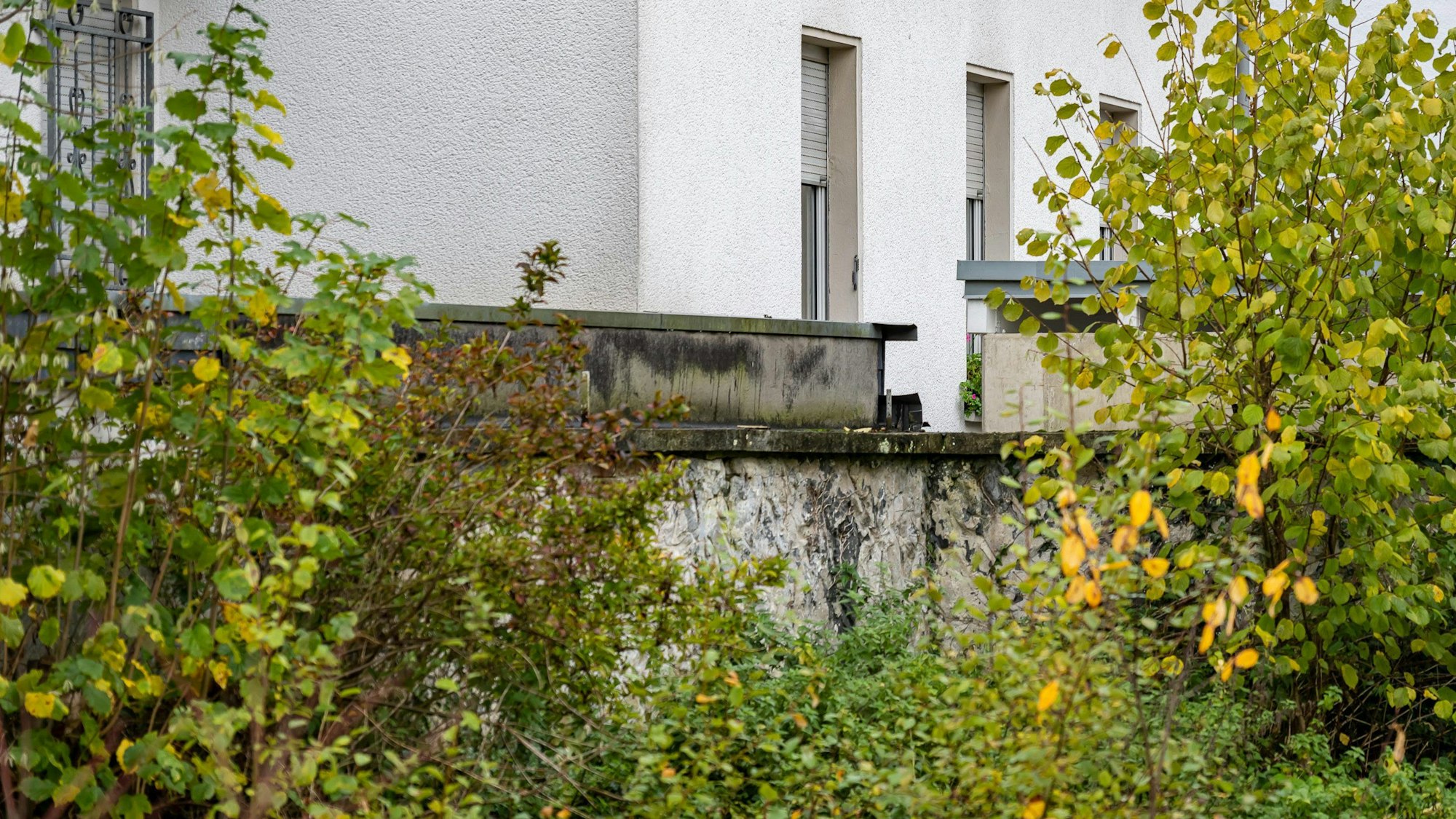 Blick auf ein weißes Haus hinter Buschwerk, in dem ein acht Jahre altes Mädchen fast ihr ganzes Leben lang festgehalten wurde.