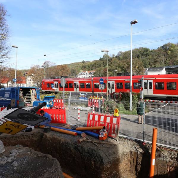 Ein Regionalzug passiert die geschlossenen Schranken am Bahnübergang Drachenfelsstraße, vor dem sich zurzeit eine Baustelle befindet.