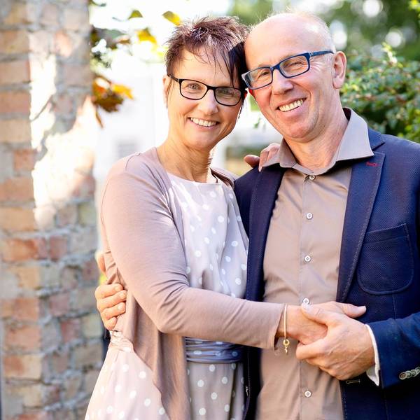 Bauer Theo steht mit seiner Freundin Andrea vor einer Hecke. Die beiden halten ihre Hände und lächeln in die Kamera.
