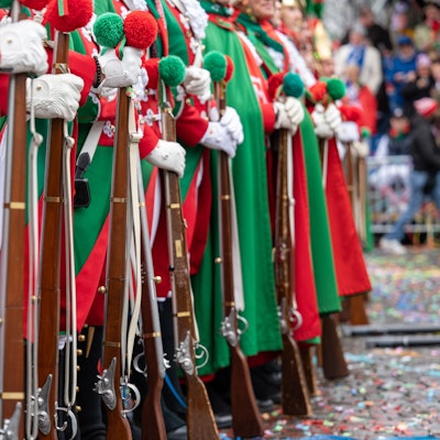 24.02.2022, Köln: Gardisten der Altstädter mit Holzgewehren an Weiberfastnacht in soldatischen Uniformen. Trotz des kriegerischen Einmarschs Russlands in die Ukraine an diesem Tag feiern Menschen die Karnevalseröffnug. Foto: Uwe Weiser