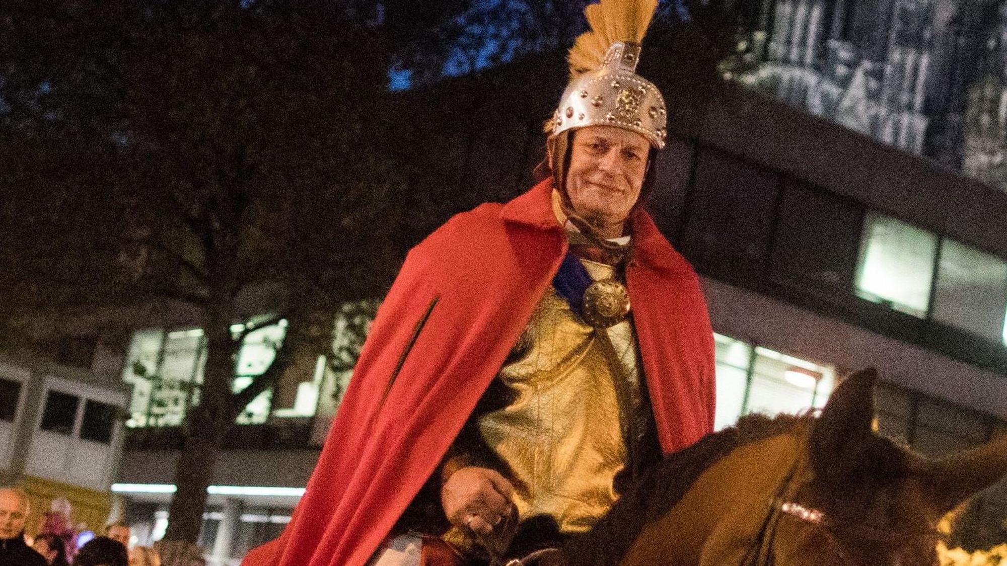 Der „Heilige Sankt Martin“ reitet bei einem Martinszug am Dom vorbei.