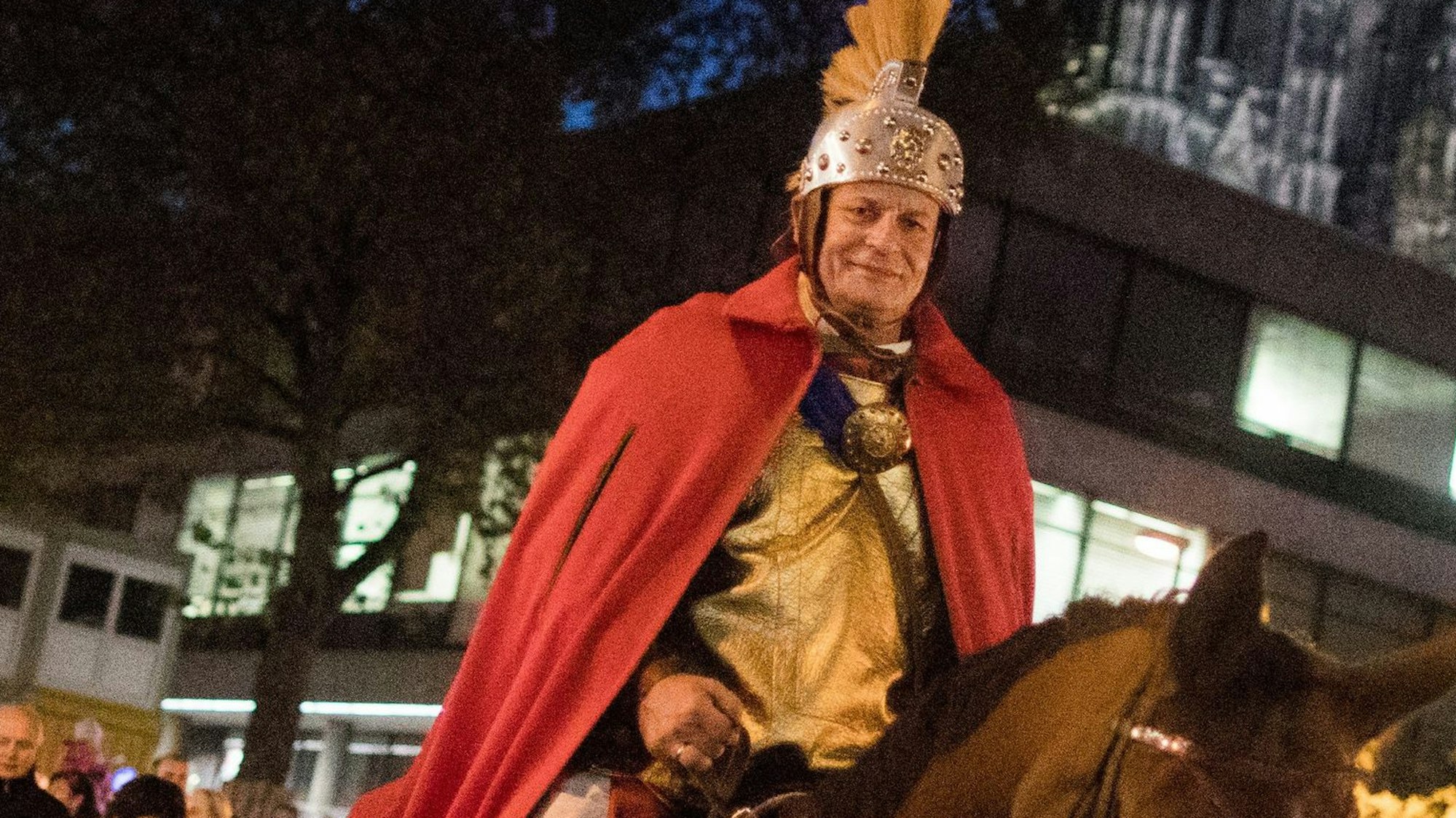 Der „Heilige Sankt Martin“ reitet bei einem Martinszug am Dom vorbei.