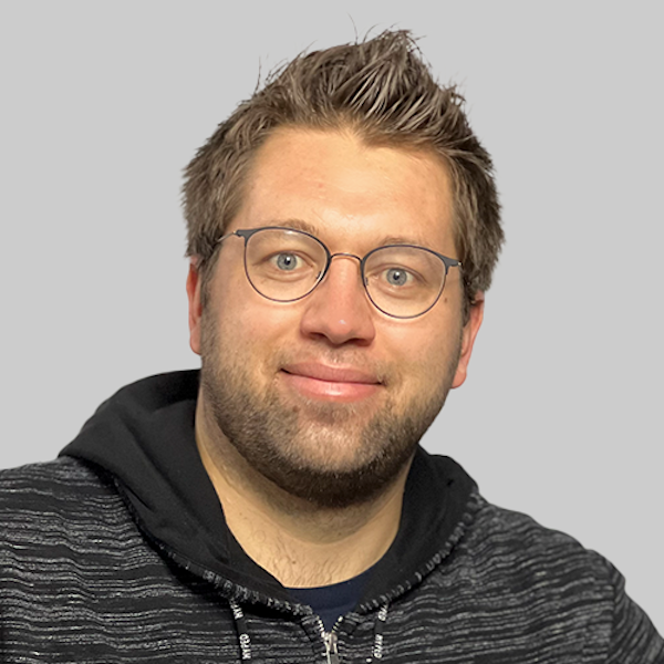 Besucher einer Informationsveranstaltung sitzen in einer Schulaula. Auf der Bühne sitzen Männer und Frauen an einem Podium.