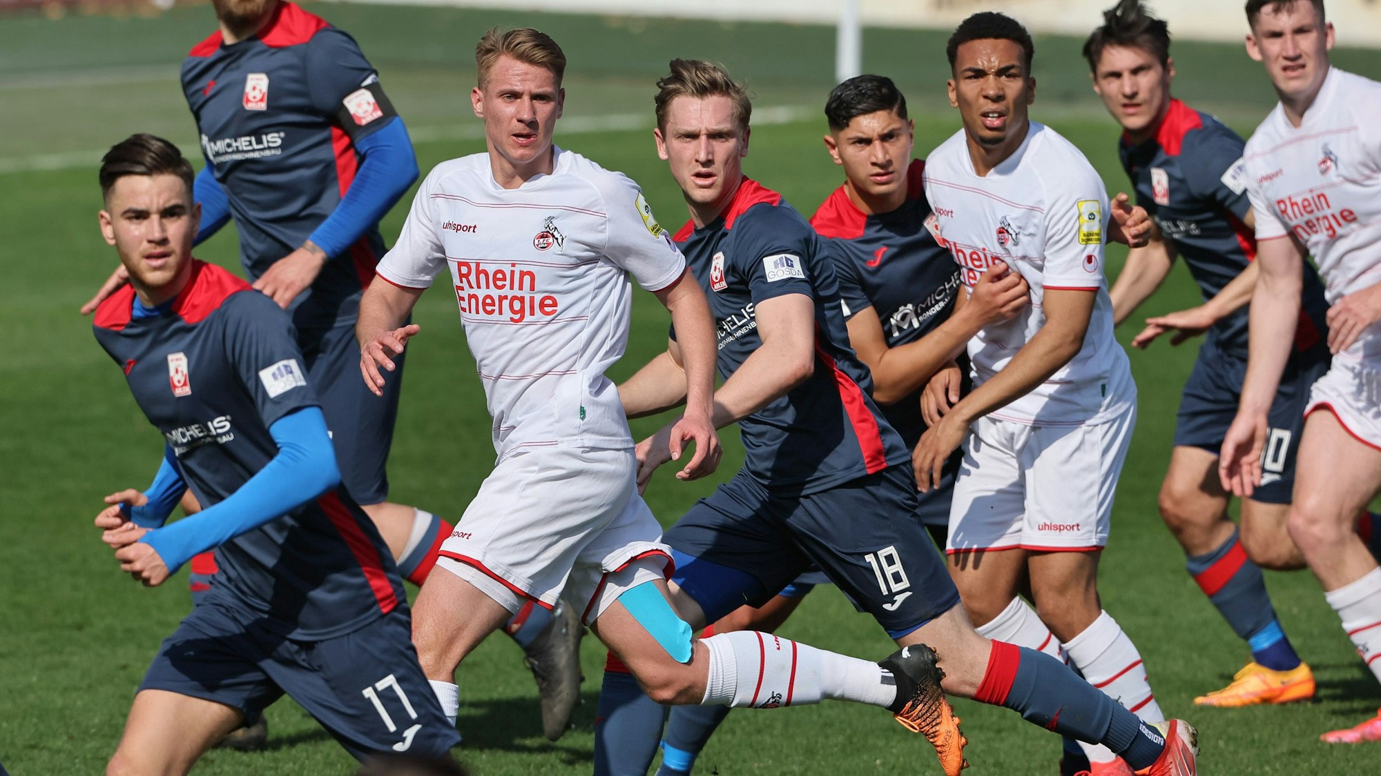 Sechs Fußballspieler schauen gespannt auf den Ball.